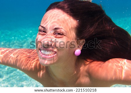 Young woman swimming undewater in the sea