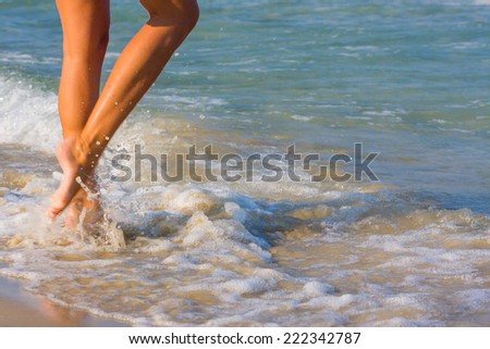 Female leg walking on the beach in the ocean - Narrow depth of field