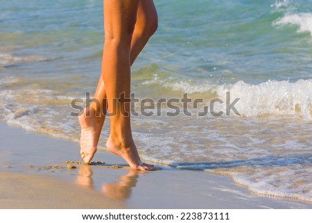 Female leg walking on the beach in the ocean - Narrow depth of field