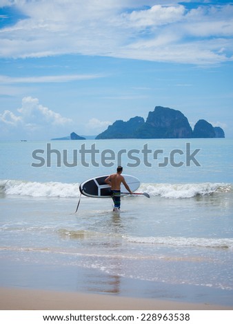 Young man stand up paddle boarding