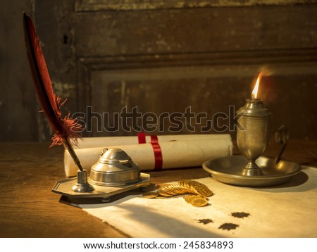 Antique parchment paper sheets lit by candlelight on a vintage colonial wood desk with ink writing feather quill, old candle light in candle-holder and gold coins