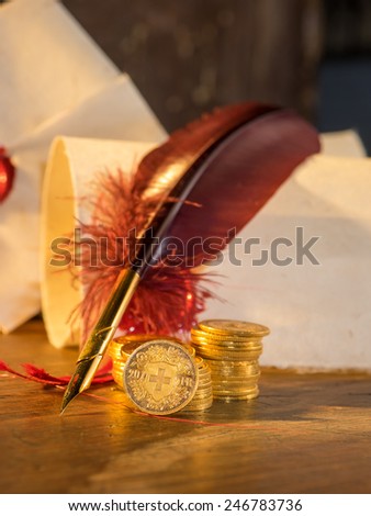 Twenty Swiss Francs gold with feather pen and old parchments