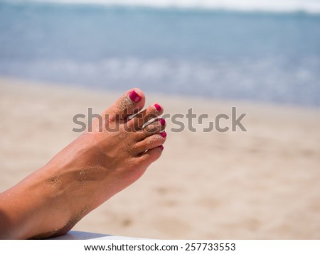 woman\'s sandy feet on the beach