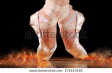 dancer in ballet shoes dancing in Pointe on a wooden floor