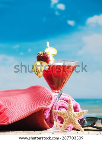 A tropical drink sitting on sand with a sky background, tropical drinks