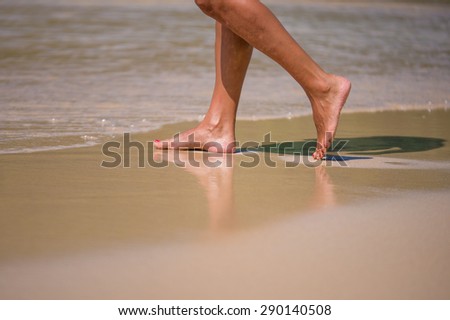 water on nice female legs on beach