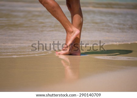 water on nice female legs on beach
