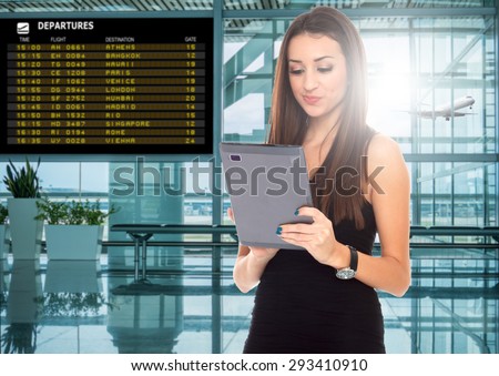 happy young woman using tablet computer at airport terminal