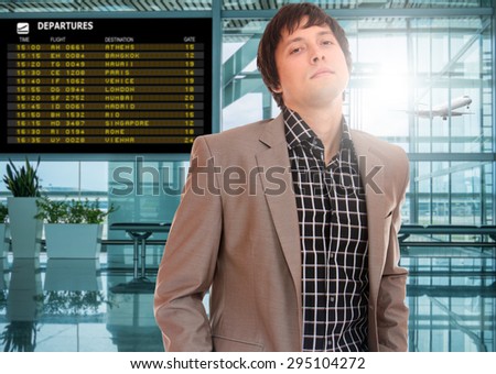 Business man at the airport terminal in front of the departure board