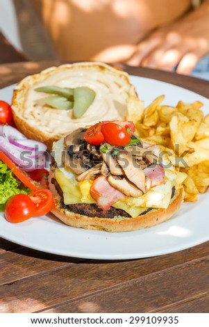 Woman eating a cheese burger at the summer lounge bar