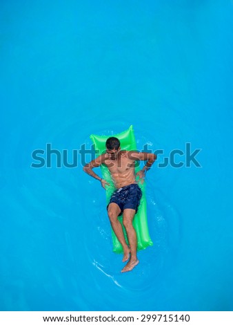 man relaxing on the air bed in the swimming pool.  vacation and free time