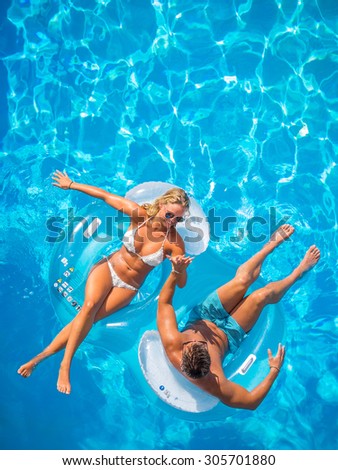 Couple Outside Relaxing In Swimming Pool in the summertime