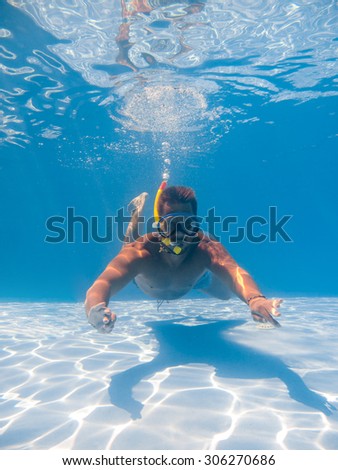 Full length of a young man wearing snorkel mask underwater