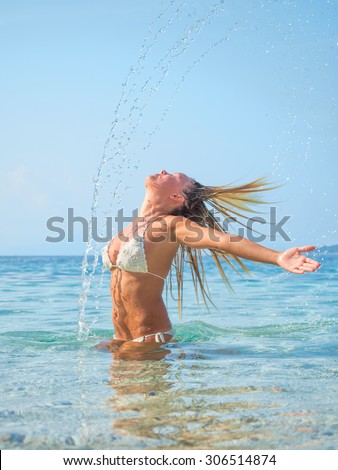 Young blonde woman  in the water waving hair