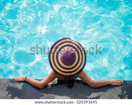 Woman in the swimming pool at tropical resort in Asia