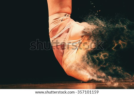 dancer in ballet shoes dancing in Pointe on a wooden floor