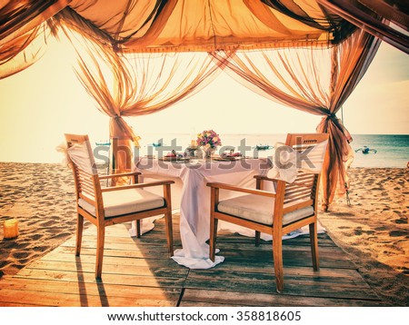 Romantic dinner setting on the beach at sunset