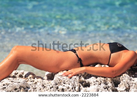 Girl in bikini tanning in the bright summer sun.