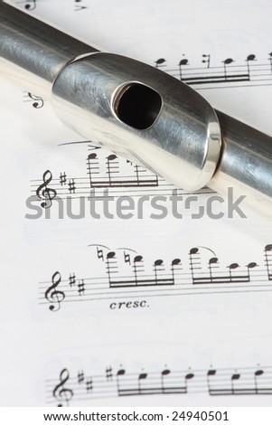 Silver flute instrument resting on a music score