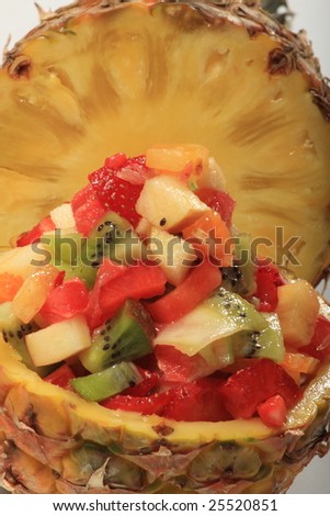 Fresh fruit salad in a pineapple on dark background