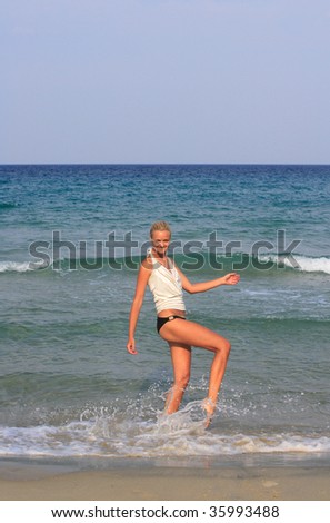 Happy young woman in sea splashing water