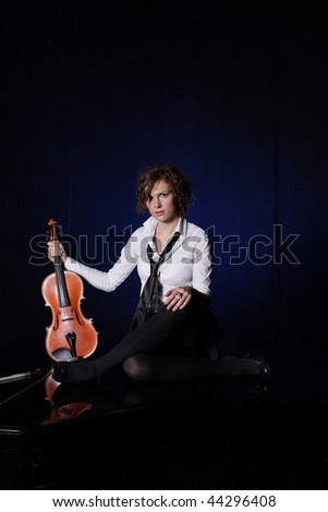 Young woman playing violin  on black background