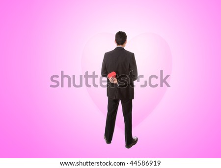 a handsome young man in suit with heart shaped gift