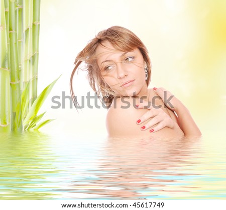 Young beautiful woman with bamboo and reflection in water