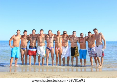 Group of eleven handsome guys on the beach