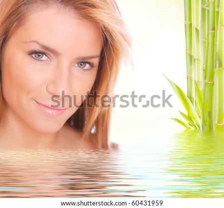 Young beautiful woman with bamboo and reflection in water