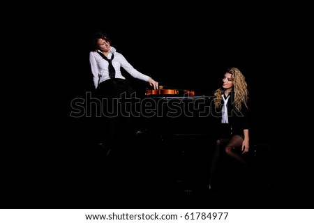 Two beautiful young sexy women posing with violon and piano