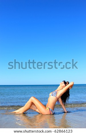 Beautiful young sexy bikini model by the sea