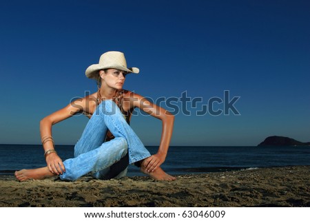 Beautiful young sexy fashion model in jeans by the sea in Greece