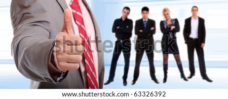 A business man with thumb with team on background
