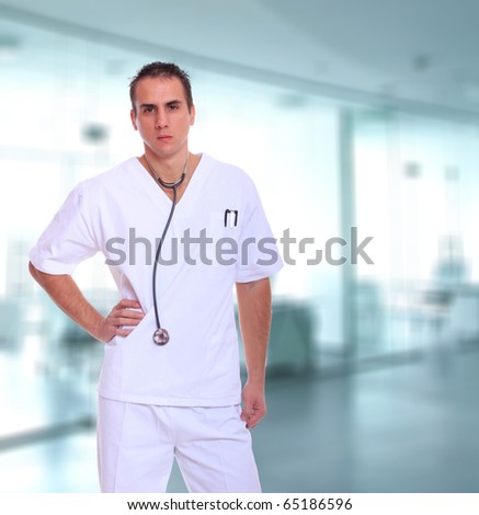 Handsome male doctor posing over light medical environment background