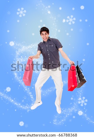 winter Portrait of a handsome young man with shopping bags jumping