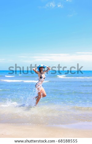 Young fashion woman running on the beach