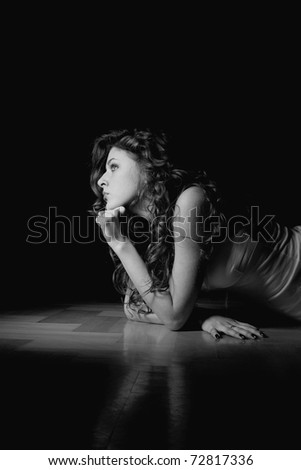 Black and white of a beautiful sexy woman on wooden floor.