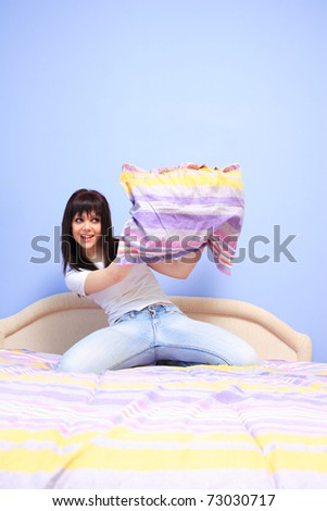Woman having pillow fight in bed
