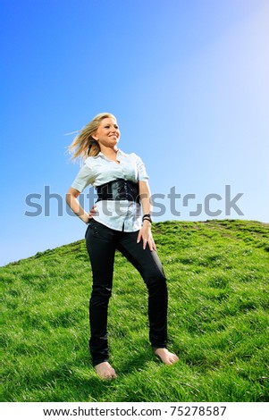 beautiful girl in white shirts and jeans on the hill arms up in the air