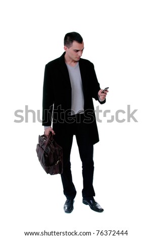 Portrait of a successful young business man on the phone carrying a suitcase on white background