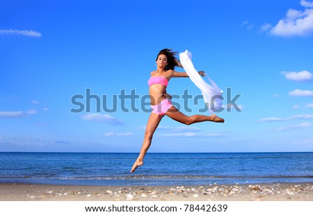 Beautiful young sexy Brazilian model jumping by the sea