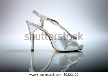 stock photo Elegant wedding shoe over gradient gray background