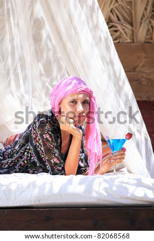 Beautiful girl relaxing outdoor at summer lounge beach club in Greece