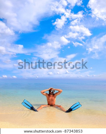 Diver with mask for a scuba diving on seacoast with sand