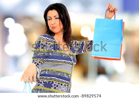 Portrait of an  attractive young girl with shopping bags in front of the shop