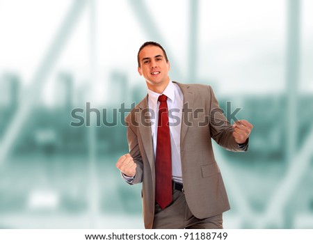 Closeup of a young business man thumb up standing in a light and modern business hall.