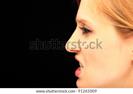 Portrait of beautiful woman profile making faces, over black background