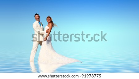 Bride and groom in the sea with water reflection
