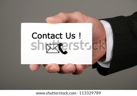 hand holding business card with the message contact us